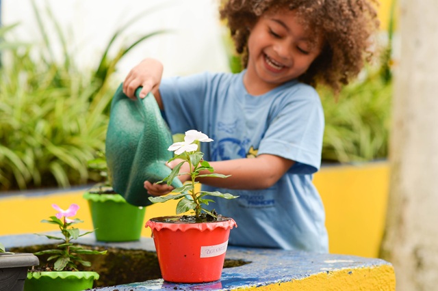 foto de menina pequena regando vaso com flor, remete a matéria SPVS firma parceria inédita com o Complexo Pequeno Príncipe e inaugura mercado de Créditos de Biodiversidade no Brasil