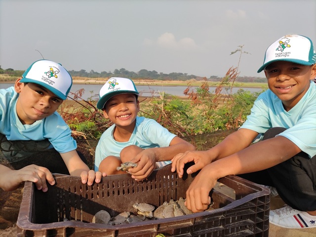 foto mostra crianças soltando os quelõnios, remete a matéria Norte Energia investe R$ 290 milhões em sustentabilidade e reforça protagonismo ambiental na Amazônia