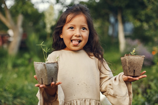 foto de criança com duas mudas nas mãos, remete a matéria SPVS: Guardiã da biodiversidade e da Mata Atlântica
