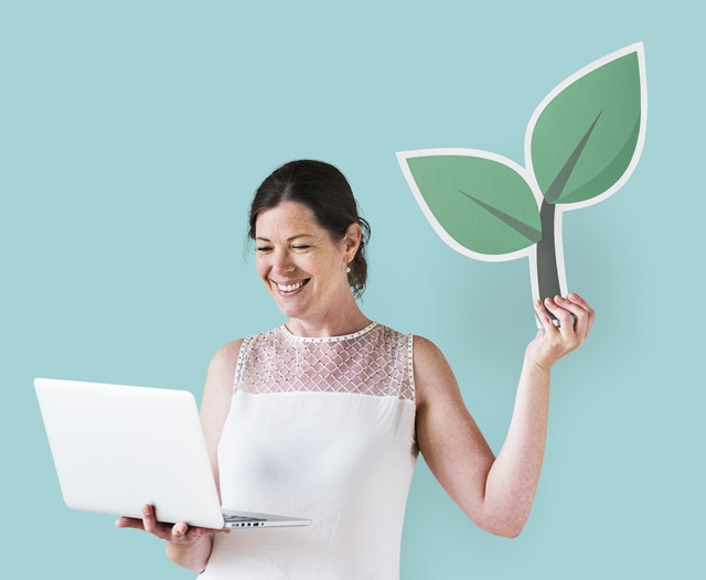 foto mostra mulher, jovem, branca, segurando a imagem de uma árvore na mão, remete a matéria Economia Verde: 6 eventos que você não pode perder em 2026