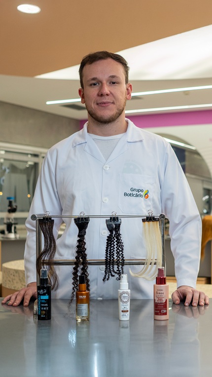 pesquisador do grupo boticário em frente as amostras de cabelos