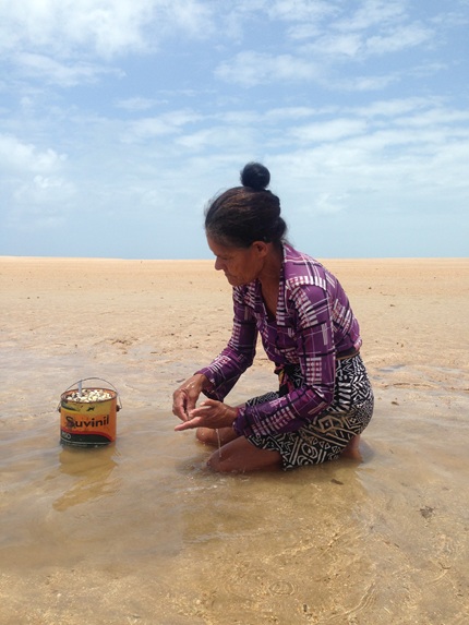 foto de mulher na praia trabalahando, remete ao artigo Em busca da resiliência oceânica