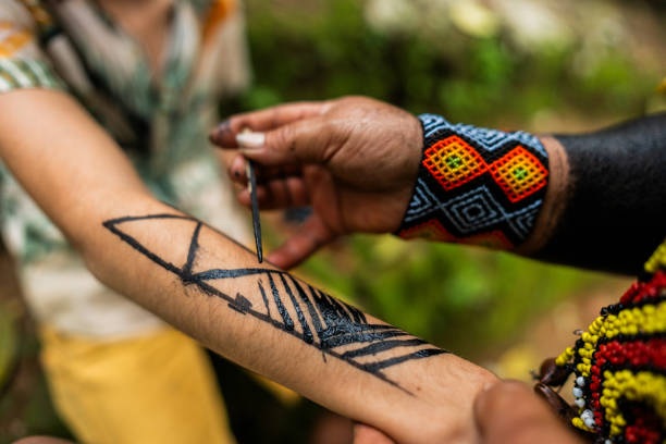 foto de um indígena pintando o braço de outra pessoa, remete a matéria O Brasil quer liderar a bioeconomia global. Mas ainda não sabe o que ela é