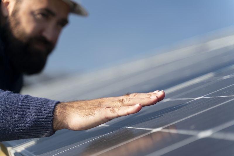 foto de homem colocando a mão em cima de painel fotovoltaico, remete a matéria Armac apoia obras em um dos maiores parques de energia renovável do País