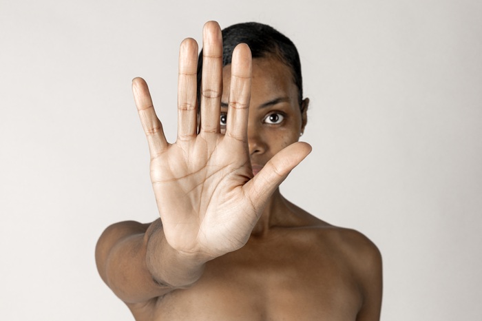 foto de mulher negra estendendo a mão fazendo um pare, remete a matéria Quando a cor da pele define o tratamento: um retrato urgente da discriminação no Brasil